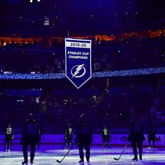 the tampa lightning hockey team stands on the ice in front of an arena with blue lights