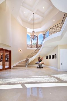 a large foyer with stairs, chandelier and pictures on the wall