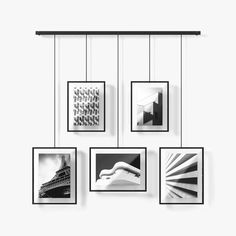 four black and white photographs hanging on a wall with frames above them, all displaying architectural details