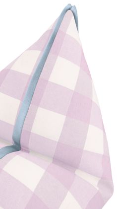 a pink and white checkered pillow with blue piping on the bottom half of it