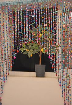 a potted plant sitting on top of a window sill covered in colorful beads