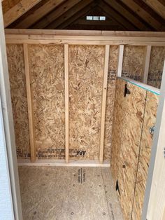 the inside of an unfinished room with wooden walls and plywood flooring in it