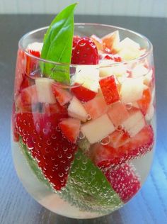 a fruit salad in a wine glass on a table