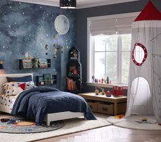 a child's bedroom decorated in blue and white with space themed wallpapers