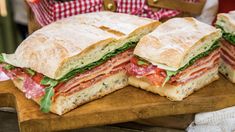 a cut in half sandwich sitting on top of a wooden cutting board