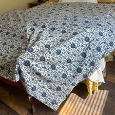 a bed covered with a blue and white bedspread