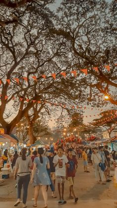 many people are walking around an outdoor market