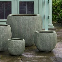 three planters sitting on the ground in front of a house