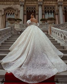 a woman in a wedding dress standing on some stairs