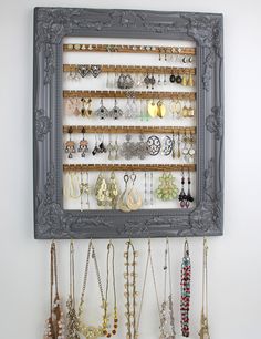 a wall mounted jewelry rack with several pairs of earrings