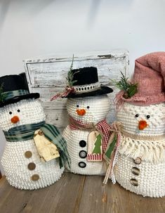 three knitted snowmen with hats and scarves