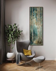 a painting hanging on the wall above a chair and ottoman in a room with wood flooring