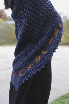 a close up of a person wearing a knitted shawl