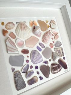 a white frame with sea glass and shells in it