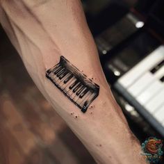 a black and white piano tattoo on the arm