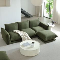 a living room with a green couch and white coffee table