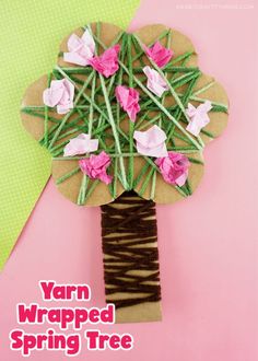 yarn wrapped spring tree craft for kids with pink flowers on top and brown sticks in the middle