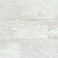 a white marble tile wall that looks like it has been painted in different shades and sizes