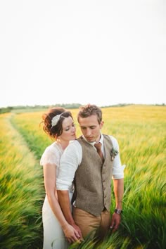 a man and woman standing next to each other in a field