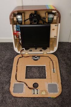 an open laptop computer sitting on top of a wooden box filled with electronic equipment and wires