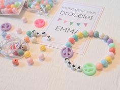 bracelets with letters and beads on a table next to a sign that says make your own braclet emma