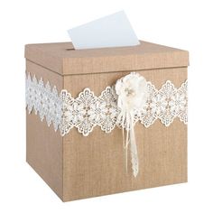 a brown box with white lace on it and a piece of paper sticking out of the top