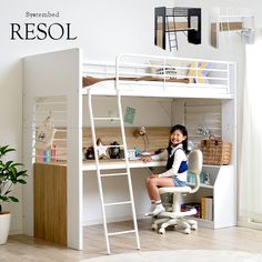 a woman sitting on top of a white bunk bed next to a potted plant