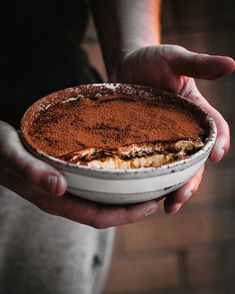 a person holding a cake in their hands