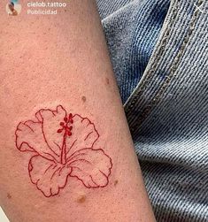 a person with a tattoo on their arm that has a red flower on the side