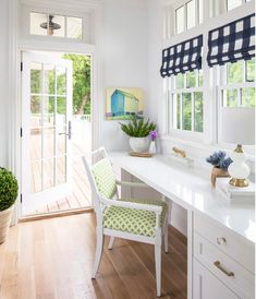 a white desk topped with a chair next to a window