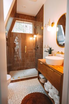 a bathroom with a sink, mirror and shower stall in the corner next to a toilet