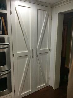 a kitchen with white cabinets and an open sliding barn door in the center, along with stainless steel appliances