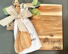 a wooden cutting board with a couple of utensils and a napkin on it