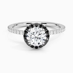 an engagement ring with black and white diamonds in the center, on a white background