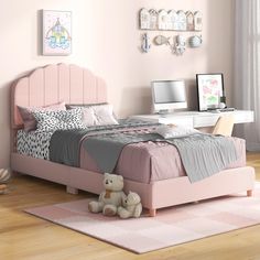 a child's bedroom with pink walls and furniture, including a large bed in the center