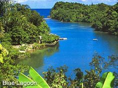 the blue lagoon is surrounded by lush green trees and tropical vegetation, with boats in the water