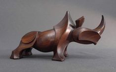 a wooden sculpture of a dog on a gray background