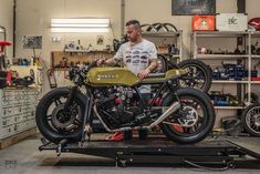 a man standing next to a motorcycle in a garage