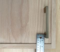 a wooden door with a measuring tape on the side and a piece of wood in front of it