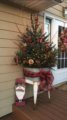 a potted christmas tree on the front porch