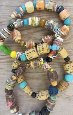 three bracelets with different colored beads on top of a wooden table next to each other