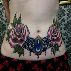 a woman's stomach with tattoos and roses on it