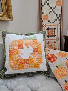 two quilted pumpkins sitting on top of a couch