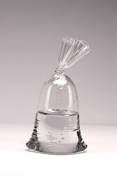 a clear glass vase with a diamond in it's top on a white surface