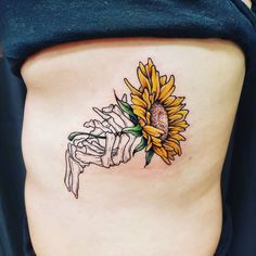 a woman's stomach with a sunflower tattoo on it