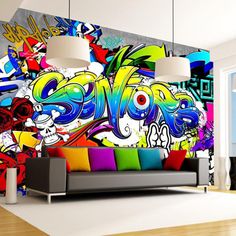 a living room filled with lots of furniture and colorful graffiti wallpaper on the walls