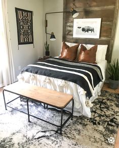 a bed room with a neatly made bed and a wooden head board on the wall