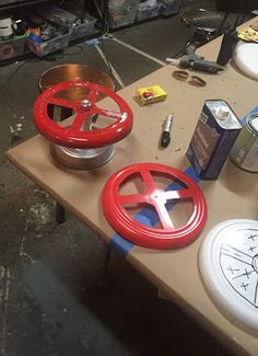 several different types of wheel rims are sitting on a table with other items in the background