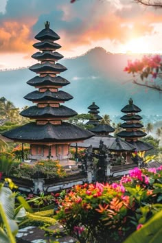 the temple is surrounded by colorful flowers and greenery, with mountains in the background