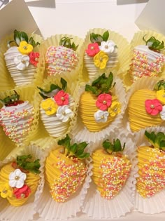 a box filled with lots of yellow and white strawberries covered in sprinkles